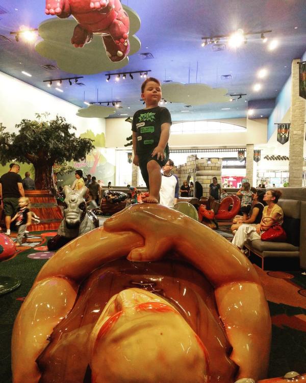 A boy stands atop a giant at Frolic's Castle in the Memorial City Mall in Houston, TX