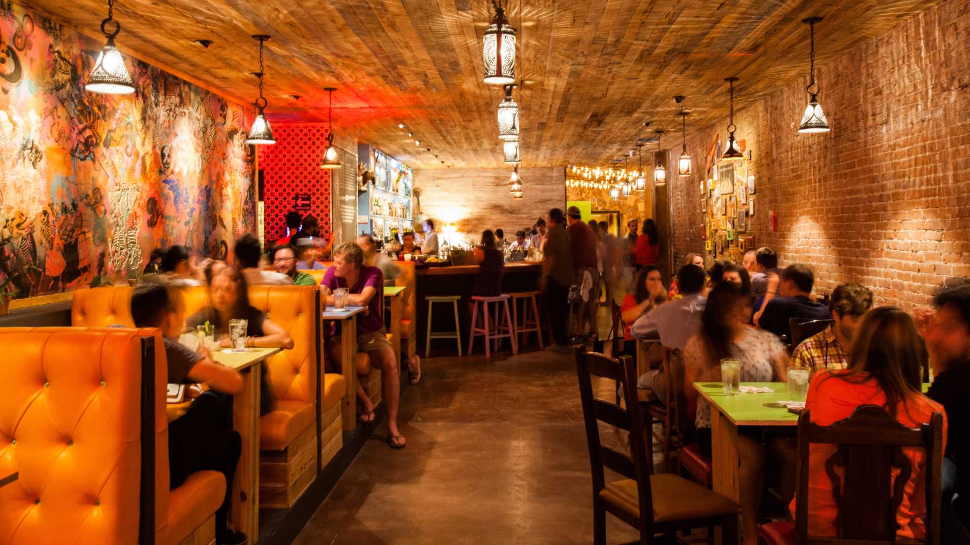 People sitting in booths inside The Pastry War in Houston